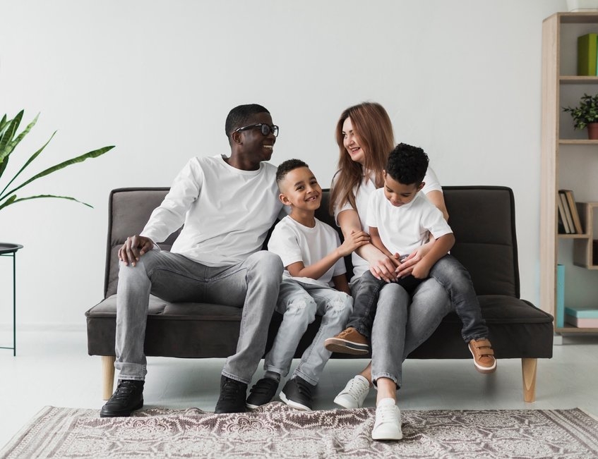 albal-famille-souriante-assise-sur-un-canape-content